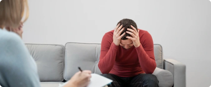 Person som sitter alene og viser tegn på depresjon under terapi