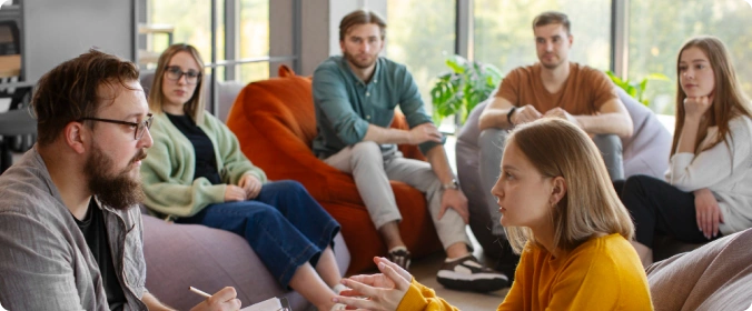 Liten gruppe klienter som deler erfaringer i gruppeterapi